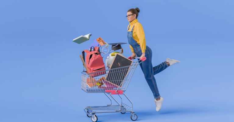 A shopper pushing a cart overflowing with backpacks, notebooks, and school supplies